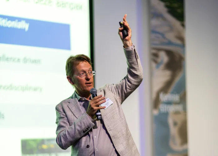 Elke stap telt
Daarna is het woord aan Gerard van der Steenhoven, hoofddirecteur KNMI. Hij schetst verschillende scenario’s die inzicht geven in hoe we de planeet op alle punten uitputten. Toch is hij hoopvol, want water, en ook klimaatverandering, verbindt. Missiegedreven, transdisciplinair en in co-creatie werken, helpt bij het vinden van oplossingen. Hoe klein ook, elk stapje helpt.